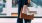 A woman standing at the shopping mall with paper bags.